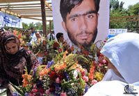 Afghan journalists place flowers in front of a photograph of the late Afghan journalist Abdul Samad Rohani during a silent mourning' gathering in Kabul on June 12, 2008. The initial findings of a government investigation indicate the Taliban shot the young BBC reporter who was found dead. AFP Photo/Shah Marai