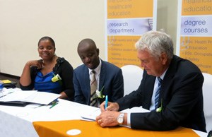 Professor Stuart Whittaker, CEO of COHSASA, signs a Memorandum of Agreement with Boitekanelo College in Botswana as (from left), Dr Khumo Seipone, Director of Health Services in the Ministry of Health and Dr Tiro Mampane, Managing Director of Boitekanelo College look on.