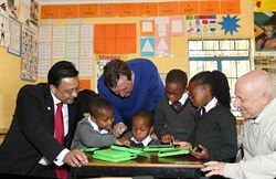 Learners of the Masibambane College in Orange Farm get to grips with their new XO tablets. From left to right: Anton Luttig, Regional Director for South and East Africa at MoneyGram; Pieter Steyn, Headmaster of Masibambane College and Mark Kaplan, Executive Director of One Laptop per Child South Africa.