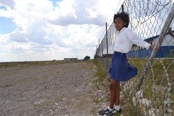 Tsholofelo Tlale, Grade 5 learner, watching the school’s co-ed cricket team, practice on the dusty grounds outside Mmuagabo Primary School