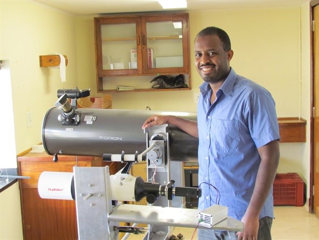 Physics students Alem Gebru at the instrument he developed for his PhD research at Stellenbosch University. The telescope uses laser radar and sunlight to remotely classify and observe the interactions of vast numbers of insects on landscape scale. Photo: Stellenbosch University