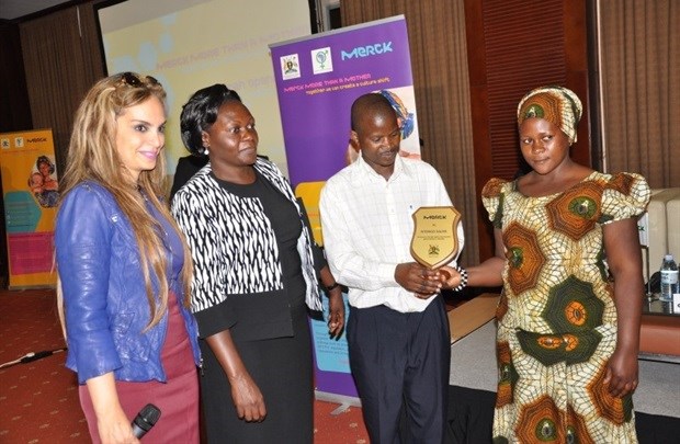 Hon. Sarah Opendi and Rasha Kelej, Chief social Officer of Merck giving a wooden shield