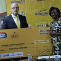 MTN’s CEO Brian Gouldie handing over a dummy cheque of MTN Marathon proceeds worth shs.500 million to executive director of Kampala Capital City Authority (KCCA), Jenifer Musisi.