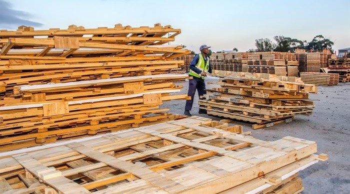 EC Wood Selections employee, Wellington Kelem, piles up wood at the Struandale plant waste yard. This wood is used by EC Wood Selections for the manufacture of furniture, pallets and crates.