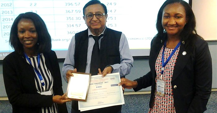 Peaceful Mathebula (left) and Tomi Oshokoya (right) receive certificates for their presentation from Professor DK Banwet (middle) in Thailand