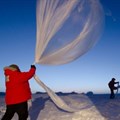 Researchers release a balloon carrying instruments to measure ozone levels above Antarctica. ,