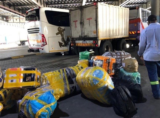Zimbabweans wait to load goods at a bus station in Johannesburg to take back to their home country for Christmas. Photo: Tariro Washinyira
