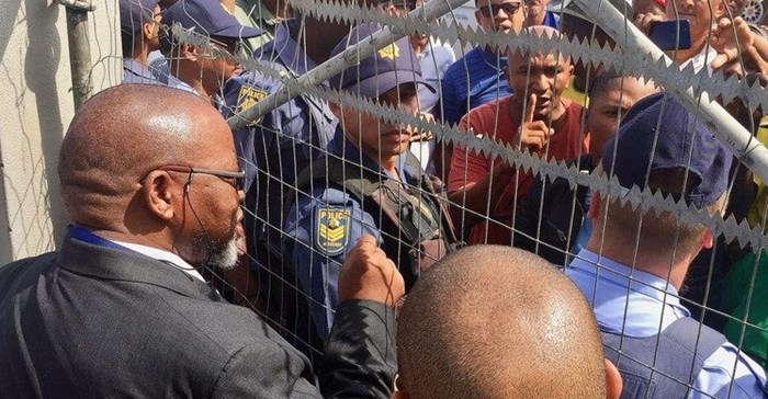 Mineral Resources Minister Gwede Mantashe talks to protesters through the locked gates of the Uitkyk Community Hall in Lutzville on Friday. Photo: John Yeld