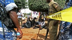 Ugandan journalists sit outside the office of the Daily Monitor, which was closed by armed police. The Monitor's website was recently ordered to suspend publication over a regulatory dispute. (Isaac Kasamani/AFP)