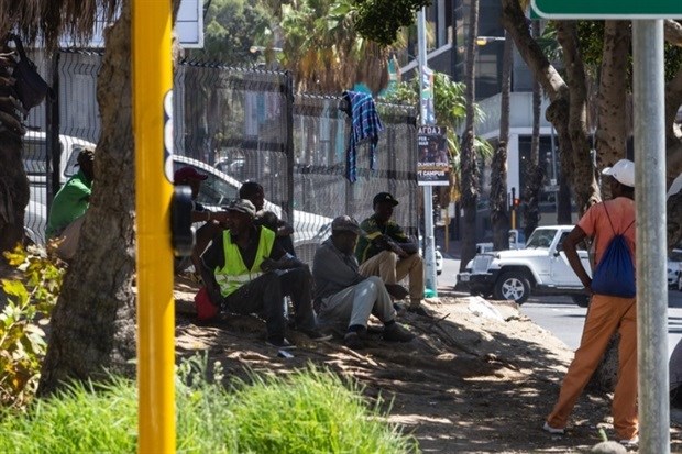 Men wait along Strand Street in Cape Town, hoping to get work for the day. This is a common sight across the city. Photo: Ashraf Hendricks