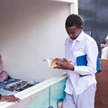 A young man looks through a book at the Hargeisa International Book Fair in the Somaliland capital of Hargeisa on July 21, 2018. Somaliland authorities recently issued a one-year suspension of the privately owned Foore newspaper. Credit: CPJ/Mustafa Saeed/AFP).