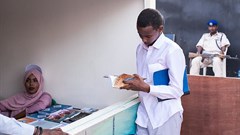A young man looks through a book at the Hargeisa International Book Fair in the Somaliland capital of Hargeisa on July 21, 2018. Somaliland authorities recently issued a one-year suspension of the privately owned Foore newspaper. Credit: CPJ/Mustafa Saeed/AFP).