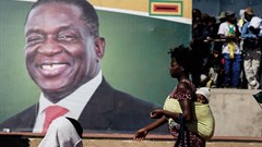 A woman walks in front of a picture of President Emmerson Mnangagwa in Bulawayo, in June 2018. Authorities in the Zimbabwean city detained documentary filmmaker Zenzele Ndebele on March 21. Credit: CPJ/AFP/Zinyange Auntony.