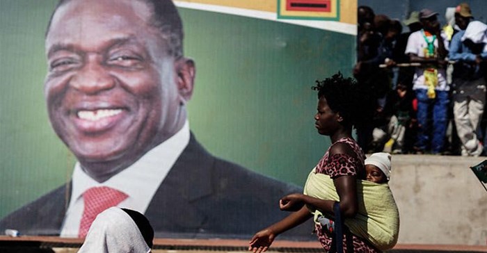 A woman walks in front of a picture of President Emmerson Mnangagwa in Bulawayo, in June 2018. Authorities in the Zimbabwean city detained documentary filmmaker Zenzele Ndebele on March 21. Credit: CPJ/AFP/Zinyange Auntony.