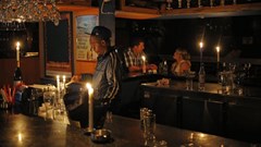 A barman using candle light as another rolling blackout affects large parts of South Africa’s biggest city, Johannesburg. Epa/Kim Ludbrook