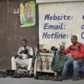 A Tanzanian shoe-shiner conducts his business underneath an election poster for then ruling party presidential candidate, and later president, John Magufuli, in Dar es Salaam, Tanzania, on October 27, 2015. On March 28, 2019, the East African Court of Justice found that multiple sections of Tanzania's Media Services Act restrict press freedom. Credit: CPJ/AP Photo/Khalfan Said.