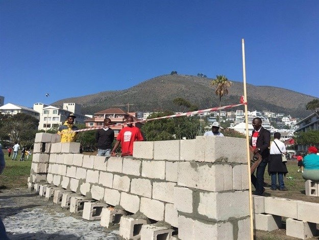 Housing activists build a wall on a Green Point bowling green on Workers’ Day. Peter Luhanga