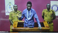Ugandan pop star and opposition figure Bobi Wine appears for his bail application via a video link from prison, on a television screen in a court in Kampala, Uganda, on May 2, 2019. Uganda's media regulator suspended staff from 13 broadcast outlets for covering his arrest. Credit: CPJ/AP/Ronald Kabuubi.