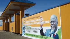 A banner of Tanzanian President John Magufuli hangs on a wall around a tanzanite mine, in April 2018. CPJ and other organizations are calling on the Human Rights Council to address a crackdown on journalists, human rights defenders, and other groups in the country. Credit: CPJ/AFP/Joseph Lyimo.