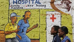 Women walk past a mural painted to raise awareness on HIV and AIDS in Kibera slum in Nairobi, Kenya. EPA/Dai Kurokawa