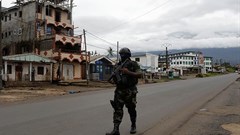 A Cameroonian elite Rapid Intervention Battalion member walks along an empty street in the city of Buea in Cameroon's Anglophone southwest region on October 4, 2018. Cameroon’s military detained pidgin news anchor Samuel Wazizi on August 2, 2019, in Buea. Credit: CPJ/Reuters/Zohra Bensemra.