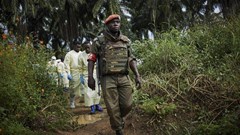 Congolese National Army solider escorts health workers to the grave of an Ebola victim, in Beni, North Kivu province. EPA-EFE/HUGH KINSELLA CUNNINGHAM