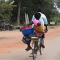 A woman and baby on a bicycle taxi in Salima, Malawi. Some Malawian men are becoming more involved in childcare. EPA-EFE