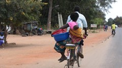 A woman and baby on a bicycle taxi in Salima, Malawi. Some Malawian men are becoming more involved in childcare. EPA-EFE