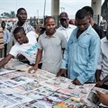 People look at front pages at a newspaper stand in Port Harcourt, after Nigeria's presidential election results were announced on February 27, 2019. Nigerian police beat two Inspiration FM journalists after covering a protest in Uyo, in Akwa-Ibom State, on September 24, 2019. Credit: CPJ/AFP/Yasuyoshi Chiba.