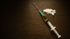 Syringe and cooked heroin. TM_SALE/Shutterstock