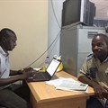 Hamza Idris (left), an editor with the Daily Trust newspaper, sits with colleague Hussaini Garba Mohammed in their office in the Nigerian capital, Abuja, in February 2019. The office was raided in January by the military, who seized 24 computers. Credit: CPJ/Jonathan Rozen.