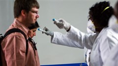 Kenyan health workers from port health services screen inbound travellers for temperatures at Nairobi’s Jomo Kenyatta International Airport. EPA/Daniel Irungu