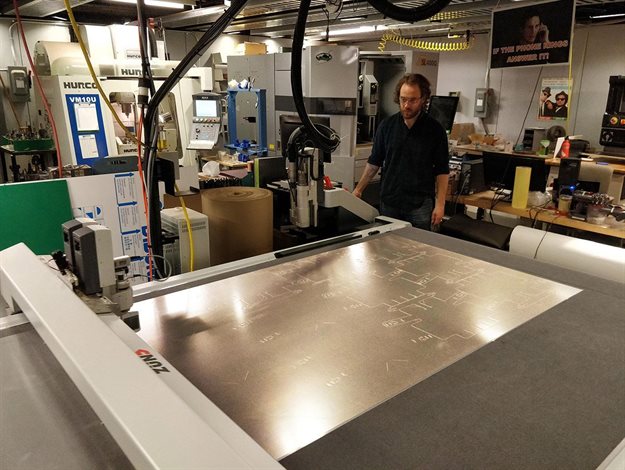 Graduate student Zach Fredin operates the Zund large-format cutter in MIT’s Center for Bit and Atoms. The machine was used to make prototypes of the face shield. Image © Center for Bits and Atoms