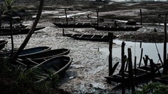Oil smeared fishboats on oily mud in the river during low tide at K-Dere, near Bodo in the Niger Delta region Yasuyoshi Chiba/AFP via Getty Images