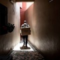 A community health worker carries a box of protection masks in Dakar on April 16, 2020. JOHN WESSELS/AFP via Getty Images