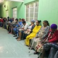 Queue of seated outpatients, waiting patiently inside a provincial hospital corridor in Port Elizabeth. Shutterstock