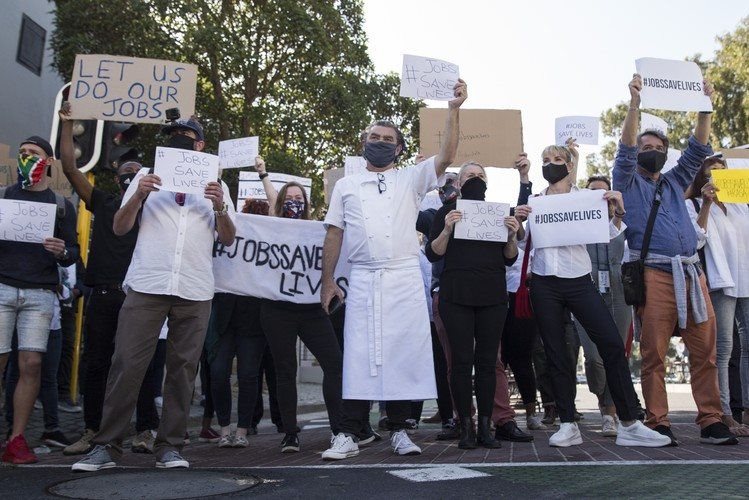 Chef Liam Tomlin (centre) owner of Chefs Warehouse, stood with protesters in Bree Street, Cape Town. He said about 300 employees could lose their jobs in his restaurants. Photo: Ashraf Hendricks