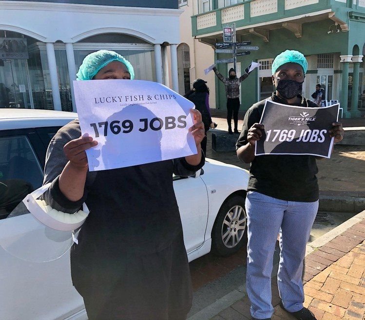 On Muizenberg beachfront, a group of protesters from Tigers Milk, Knead Bakery and Lucky Fish & Chips held placards next to the road at Surfers’ Corner. Photo: Lucas Nowicki