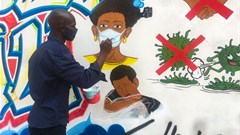 Congolese artist Chris Shongo paints on the outside wall of the Academie des Beaux-Arts in Kinshasa on June 18, 2020.