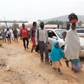 People walking next to traffic in Abuja, Nigeria’s capital city.
Photo by Kola Sulaimon/AFP via Getty Images