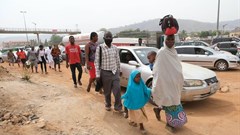 People walking next to traffic in Abuja, Nigeria’s capital city.
Photo by Kola Sulaimon/AFP via Getty Images