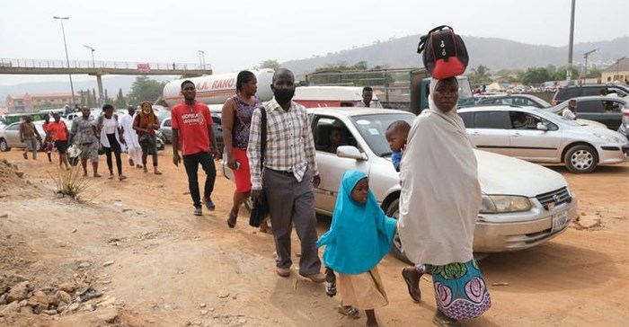 People walking next to traffic in Abuja, Nigeria’s capital city.
Photo by Kola Sulaimon/AFP via Getty Images