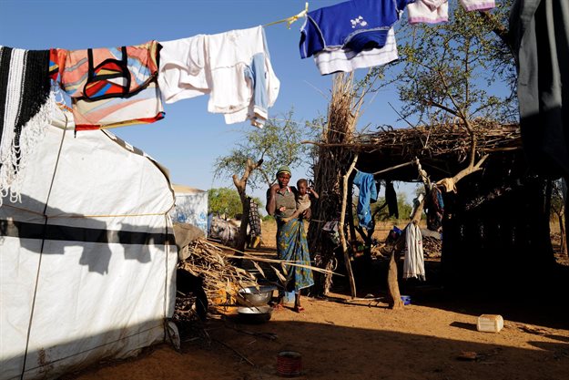 A woman who fled from attacks of armed militants the in Sahel region holds her child as she stands besides her tent at a camp for internally displaced people (IDPs) in Kaya, Burkina Faso, 23 November 2020. Reuters/Zohra Bensemra