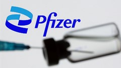 Syringe and vial are seen in front of displayed new Pfizer logo in this illustration taken, 24 June 2021. Reuters/Dado Ruvic/Illustration