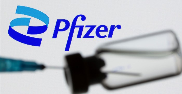 Syringe and vial are seen in front of displayed new Pfizer logo in this illustration taken, 24 June 2021. Reuters/Dado Ruvic/Illustration