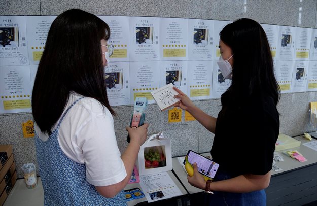 Women take a look at items at a faeces currency market at Ulsan National Institute of Science and Technology (UNIST) in Ulsan, South Korea, 6 July 2021. Reuters/Daewoung Kim