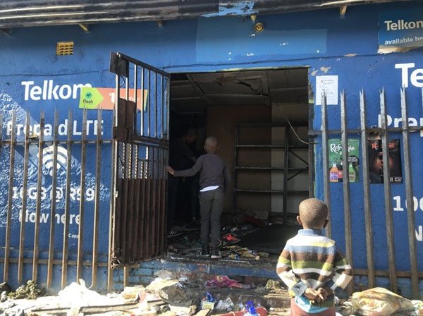 Children stand at the door of a looted shop in Alexandra, Johannesburg. Photos: Masego Mafata
