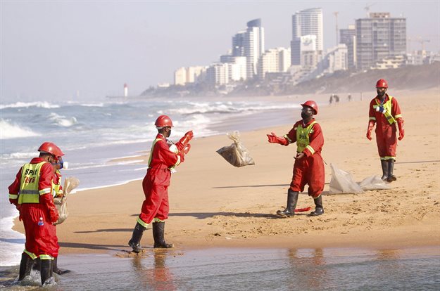 Members of a hazardous waste cleanup crew handle bags of dead fish collected after chemicals entered the water system from a warehouse which was burned during days of looting, vandalism and arson in South Africa. Reuters/Rogan Ward