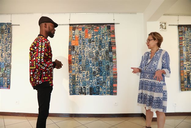Ivorian painter Aristide Kouame, 26, who paints optical effects artworks with worn soles, talks with Eureka gallery's manager Sandrine Marmisole in Abidjan, Ivory Coast. Reuters/Luc Gnago