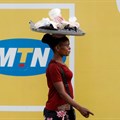 A woman walks past an advertising posters for MTN telecommunication company along a street in Lagos, Nigeria 28 August 2019. Reuters/Temilade Adelaja